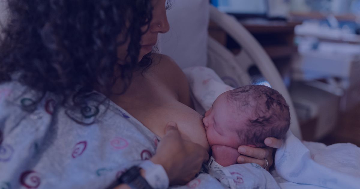 Mother Breastfeeding Newborn Baby in Hospital