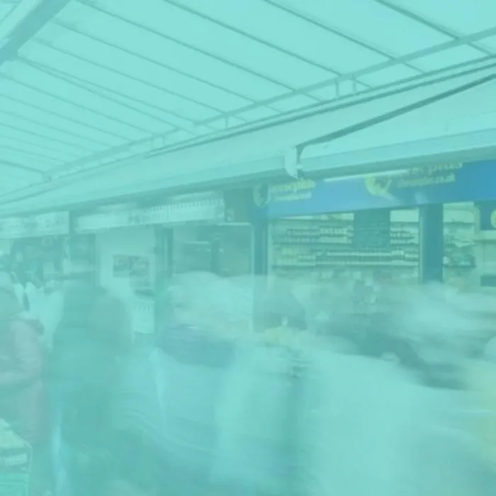 a bustling market with people walking around market stalls