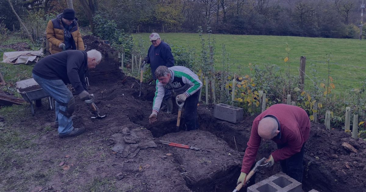 a group of men digging and preparing the ground with shovels and tools