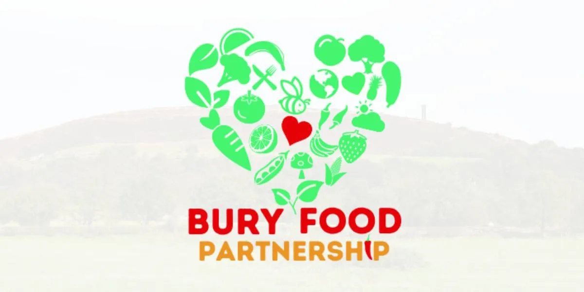 The Bury Food Partnership logo positioned over a faded image of a hill with a tall tower on top