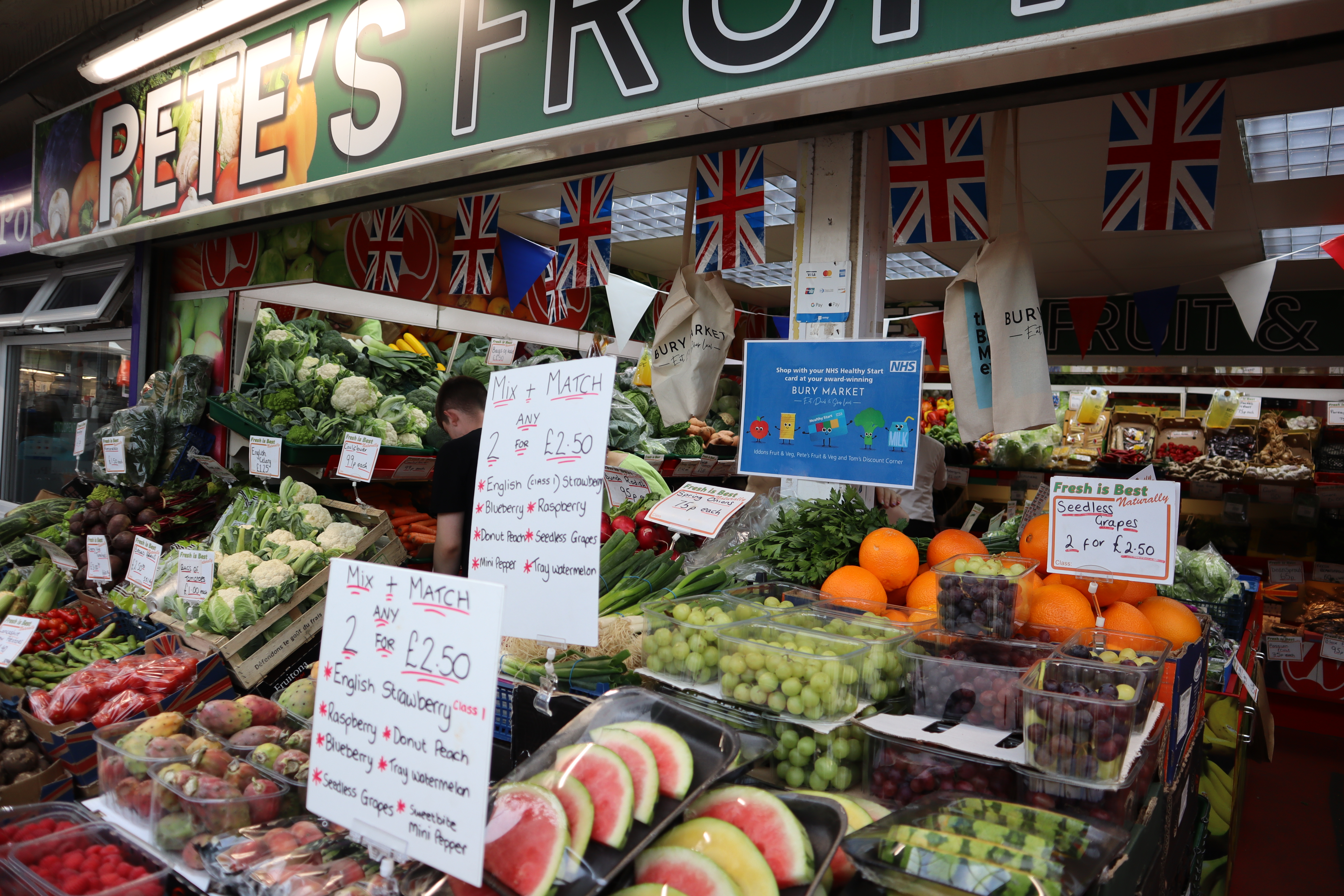 a market stall packed with fresh fruit and veg