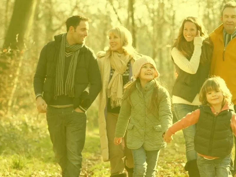 a multi generational family talking a walk in the park, with a transparent yellow overlay