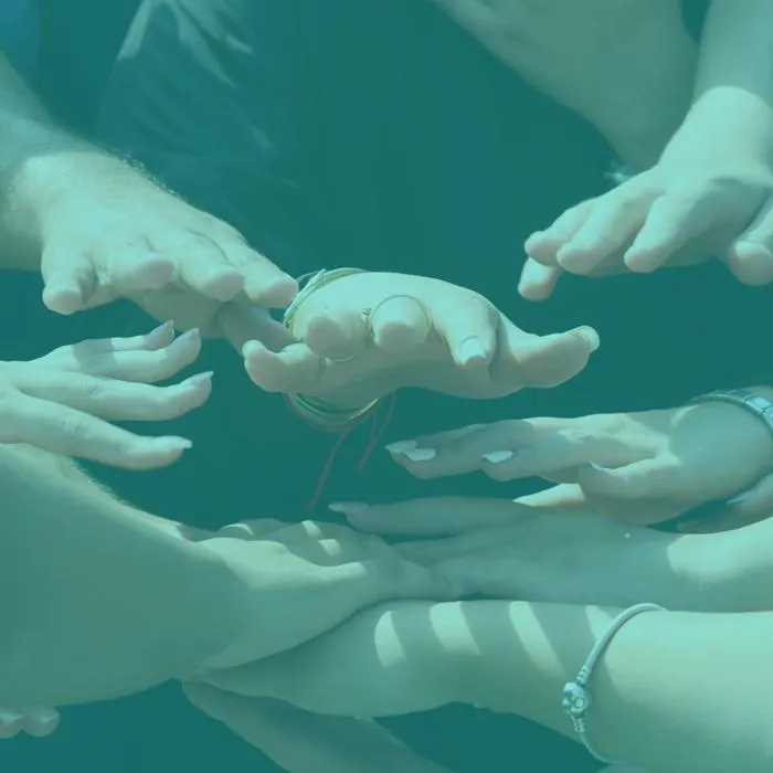 a number of hands come together to symbolize team work and partnership working