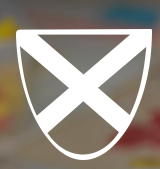 st andrews radcliffe school logo comprising white shield with diagonal lines across on grey background