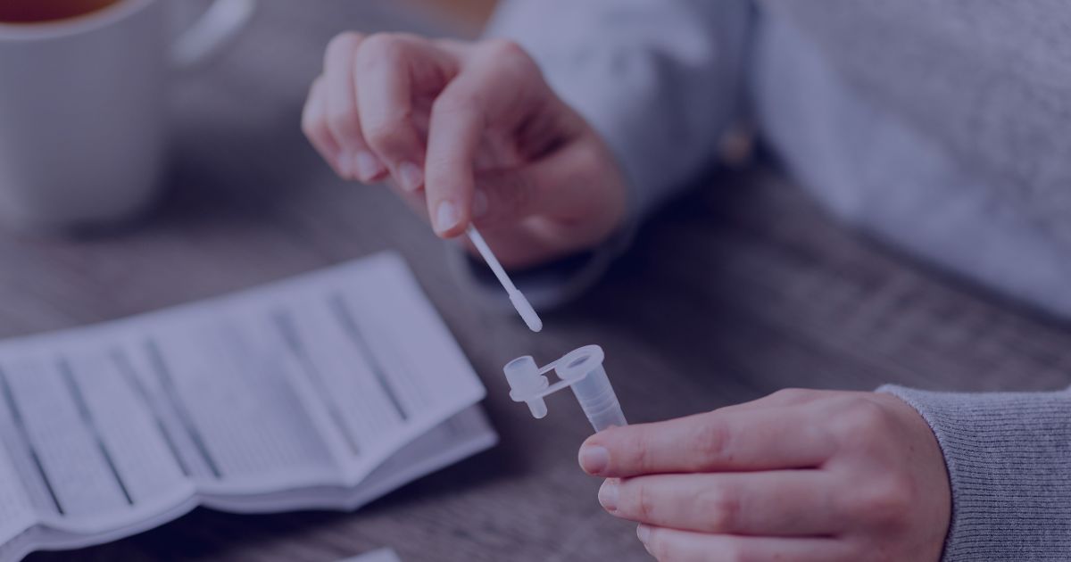 Person holding a swab and test tube while preparing to take an STI test.