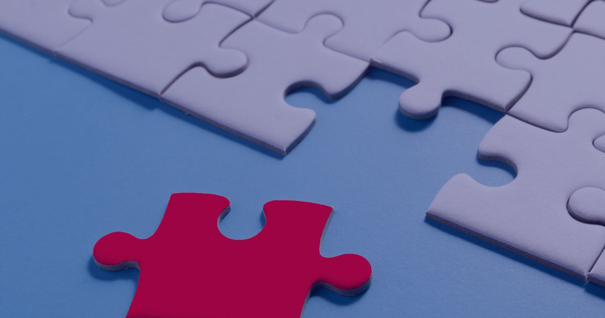 A single red puzzle piece about to complete a nearly finished jigsaw, symbolizing the importance of every part in solving a complex problem.