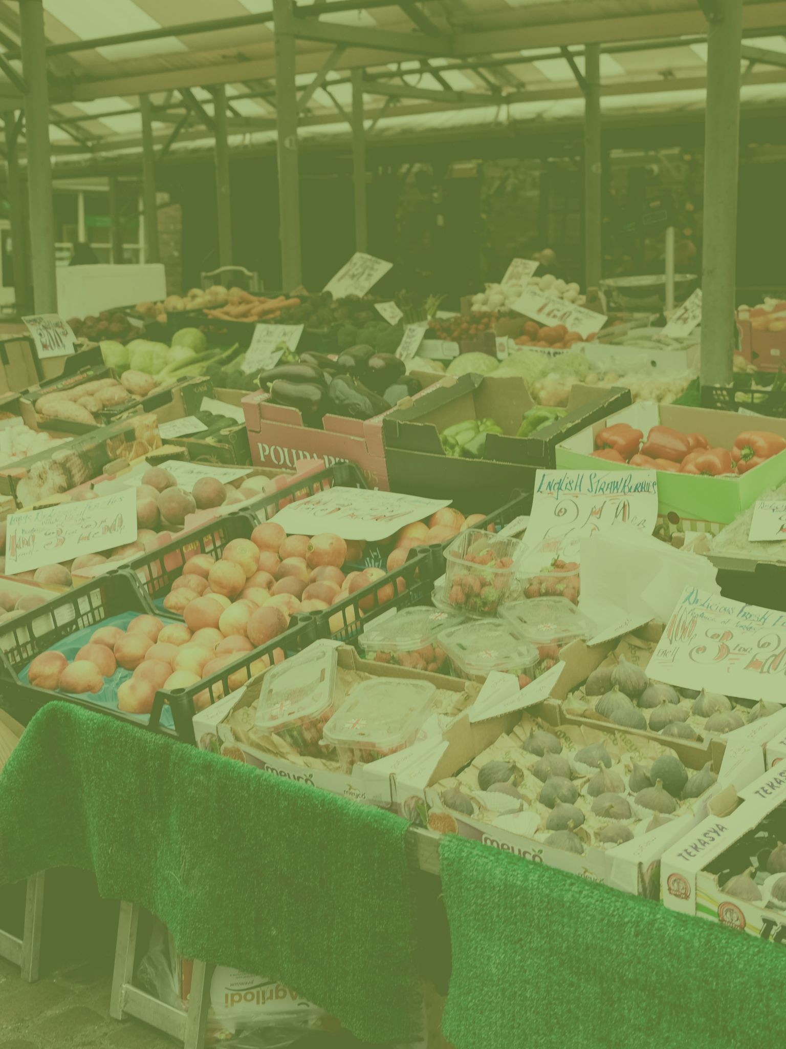 a market stall with boxes of fruit and veg on display