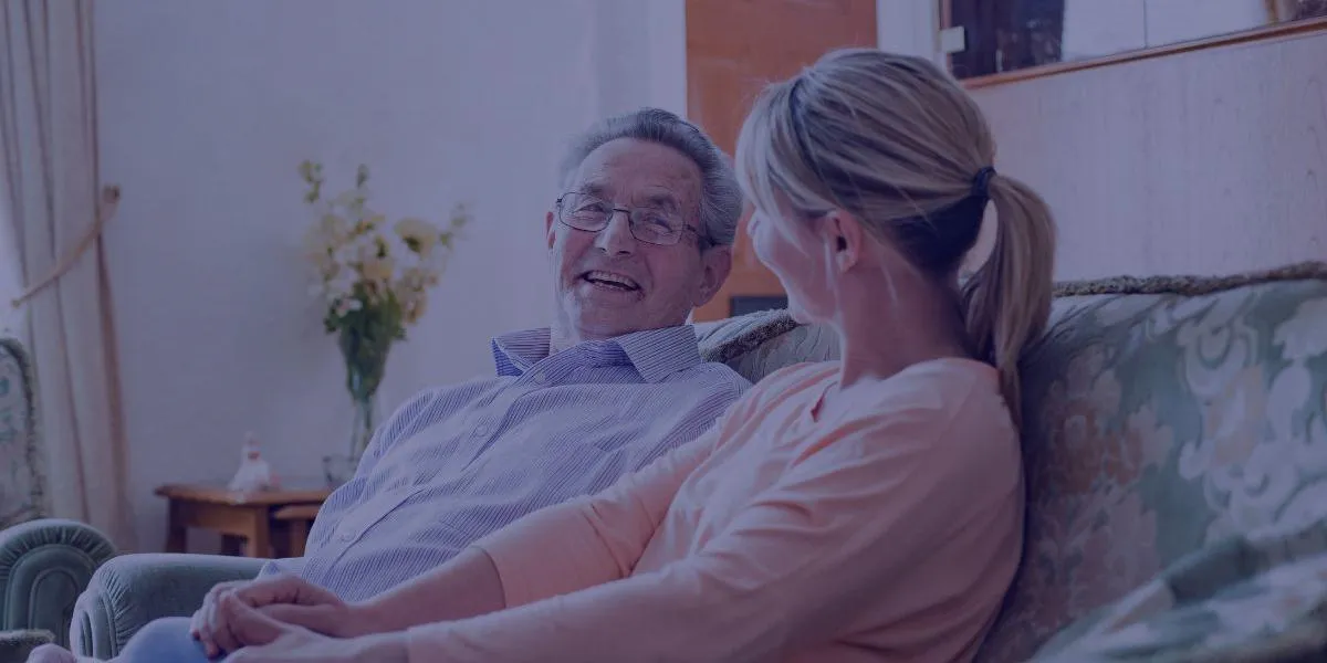 Unpaid carer sitting on the sofa smiling