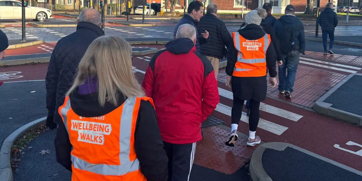 A group of people walking in Bury town centre on one of the local wellbeing walks.